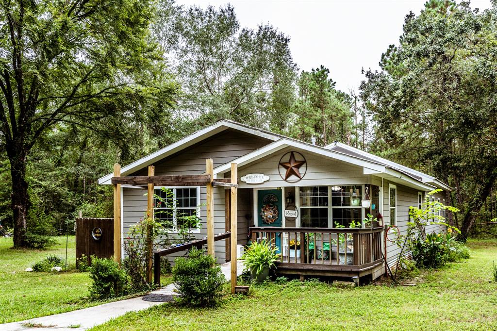 a view of a house with a yard and potted plants