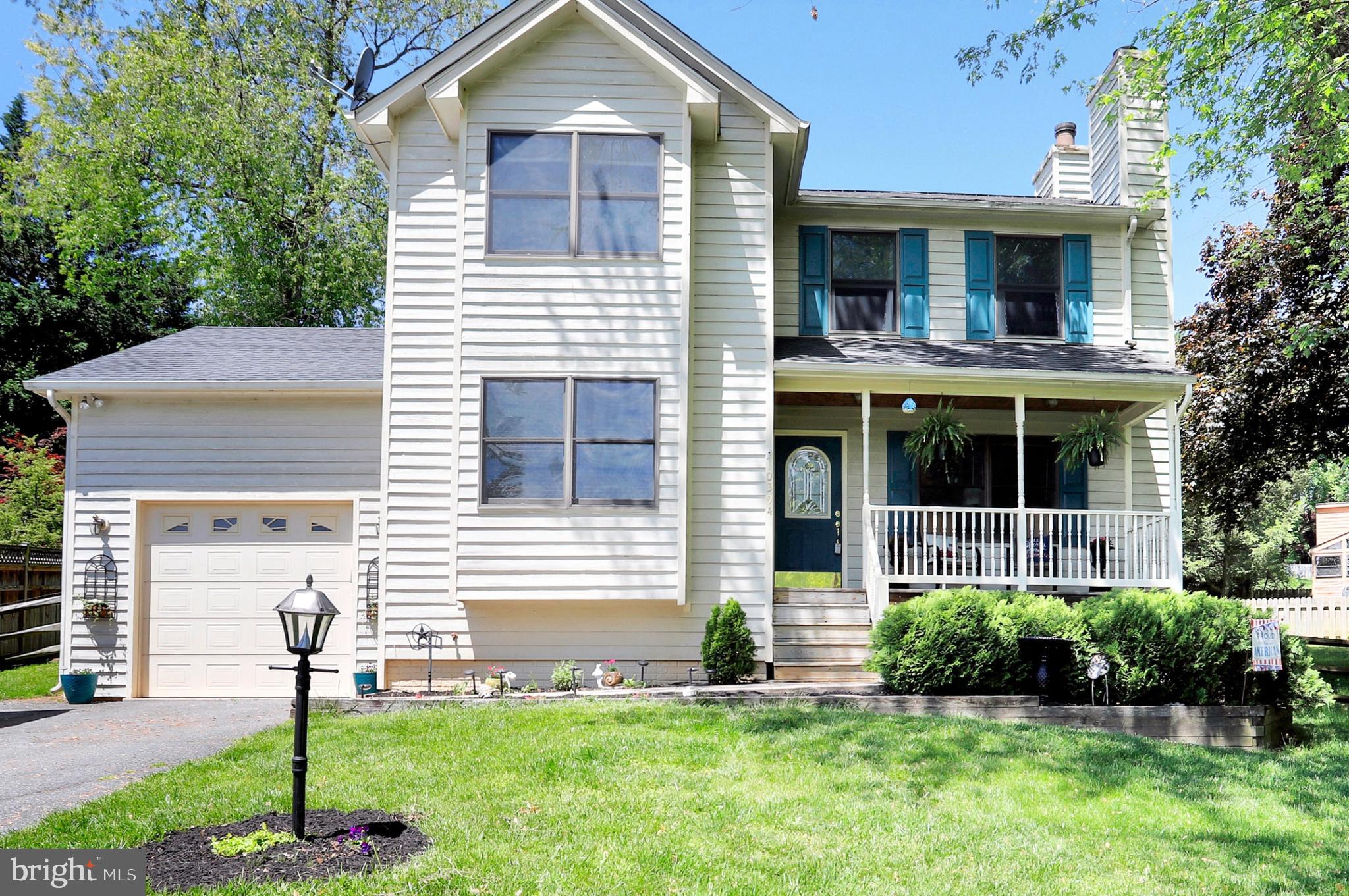 a front view of a house with a yard and trees