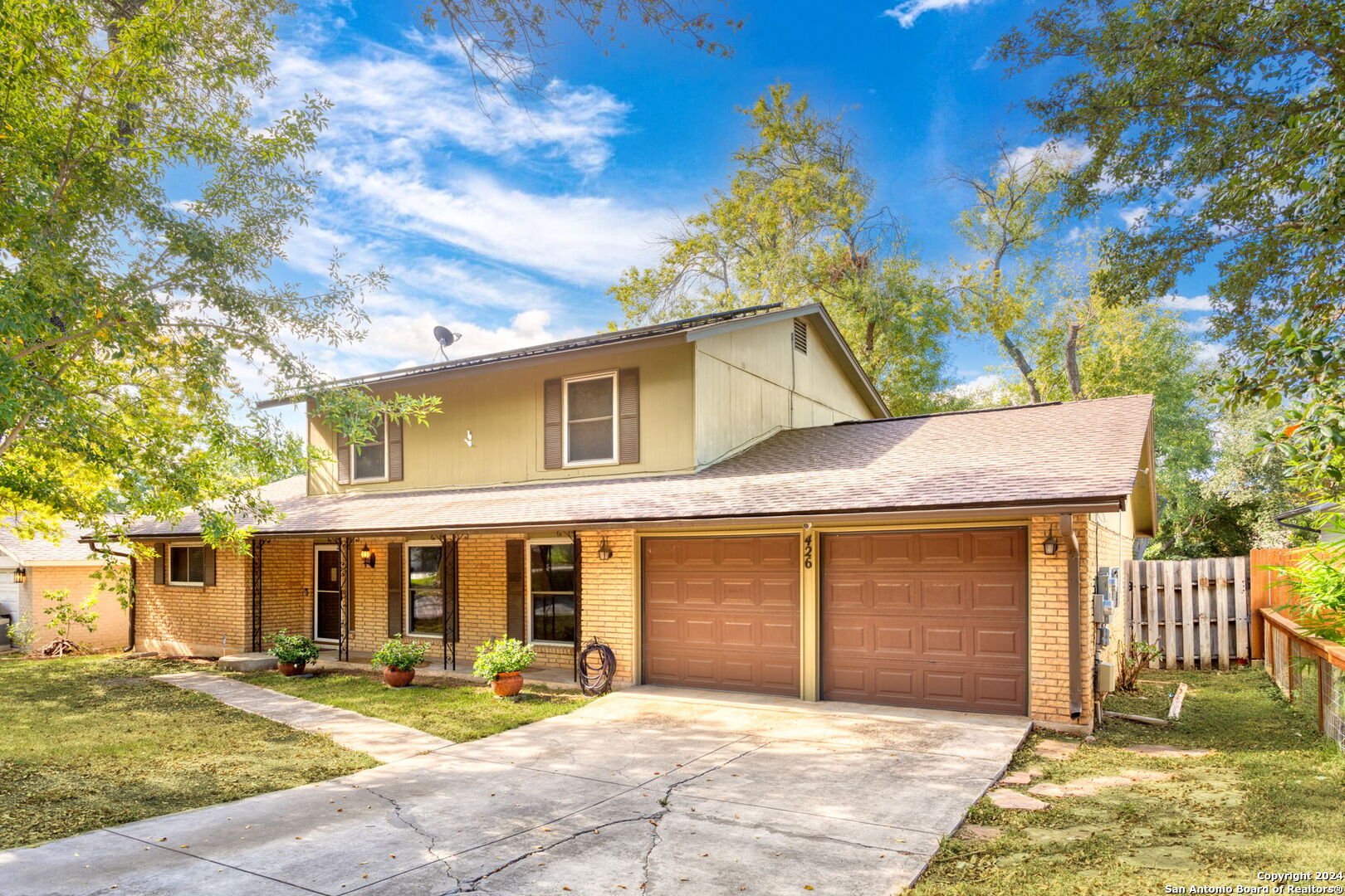 a view of a house with a patio and a yard