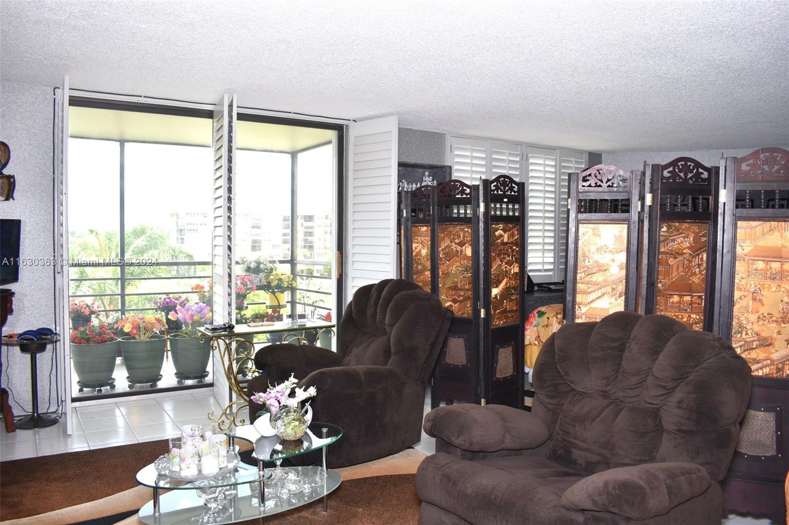 a living room with furniture and floor to ceiling windows