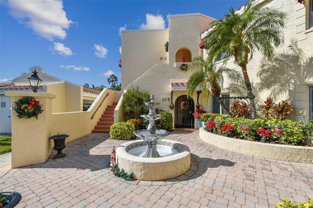 a front view of a house with fountain and a fountain