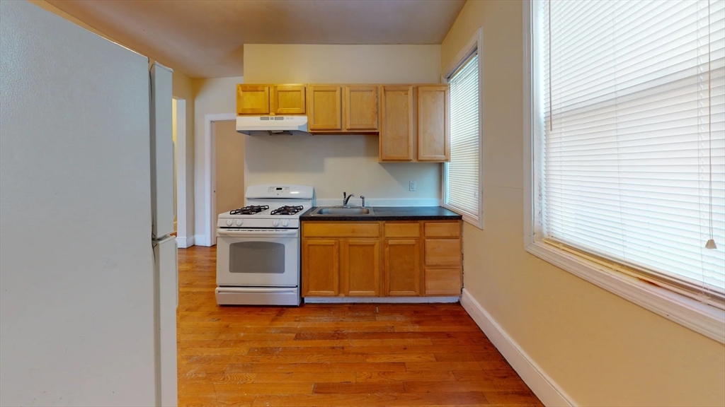 a kitchen with a sink a stove and cabinets