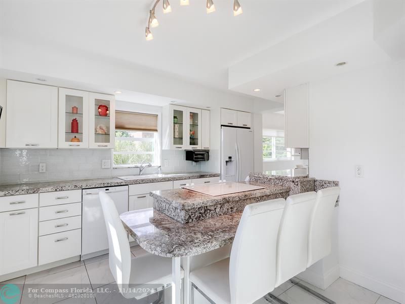 a kitchen with granite countertop a sink and white cabinets