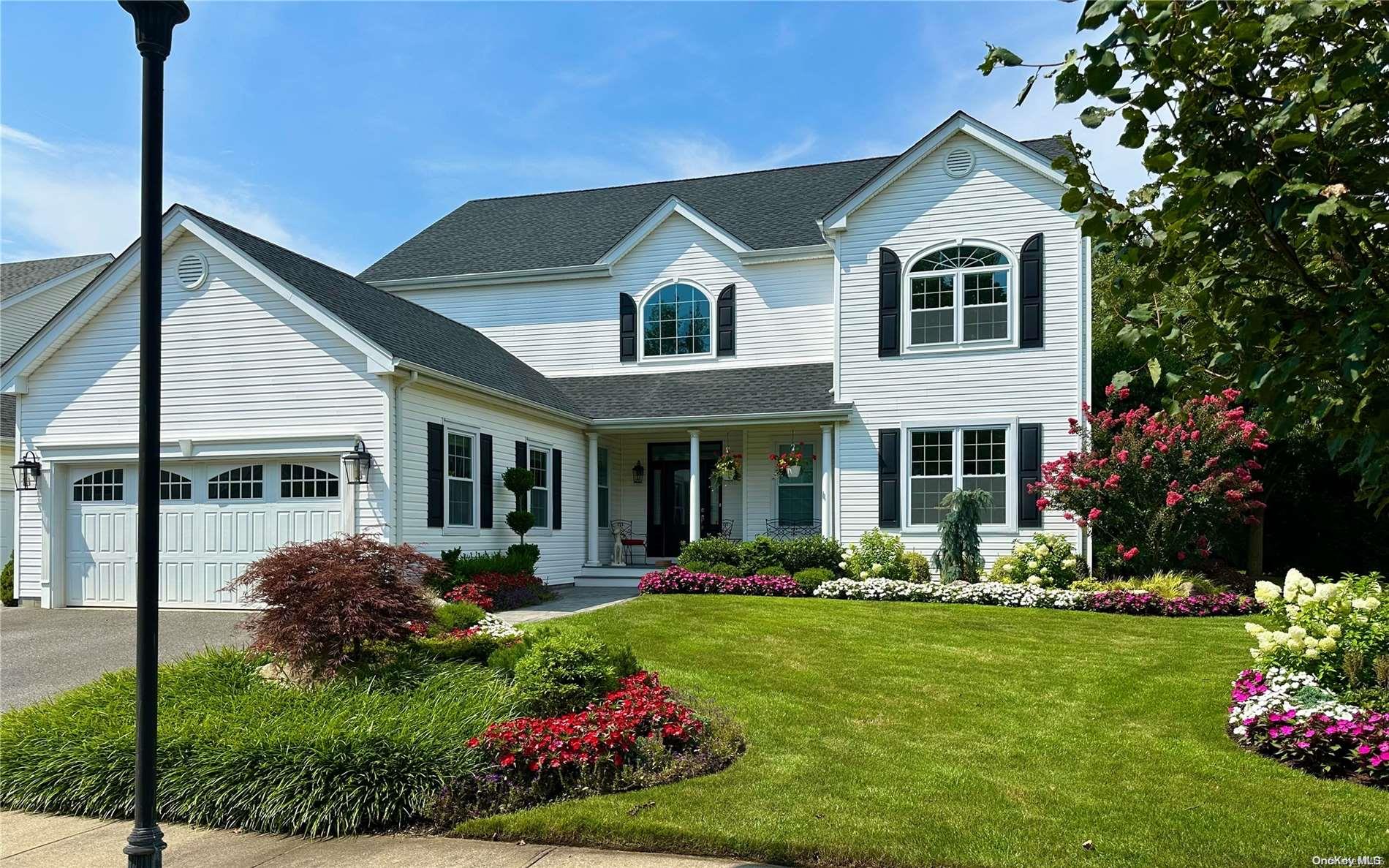 a front view of a house with a big yard and potted plants