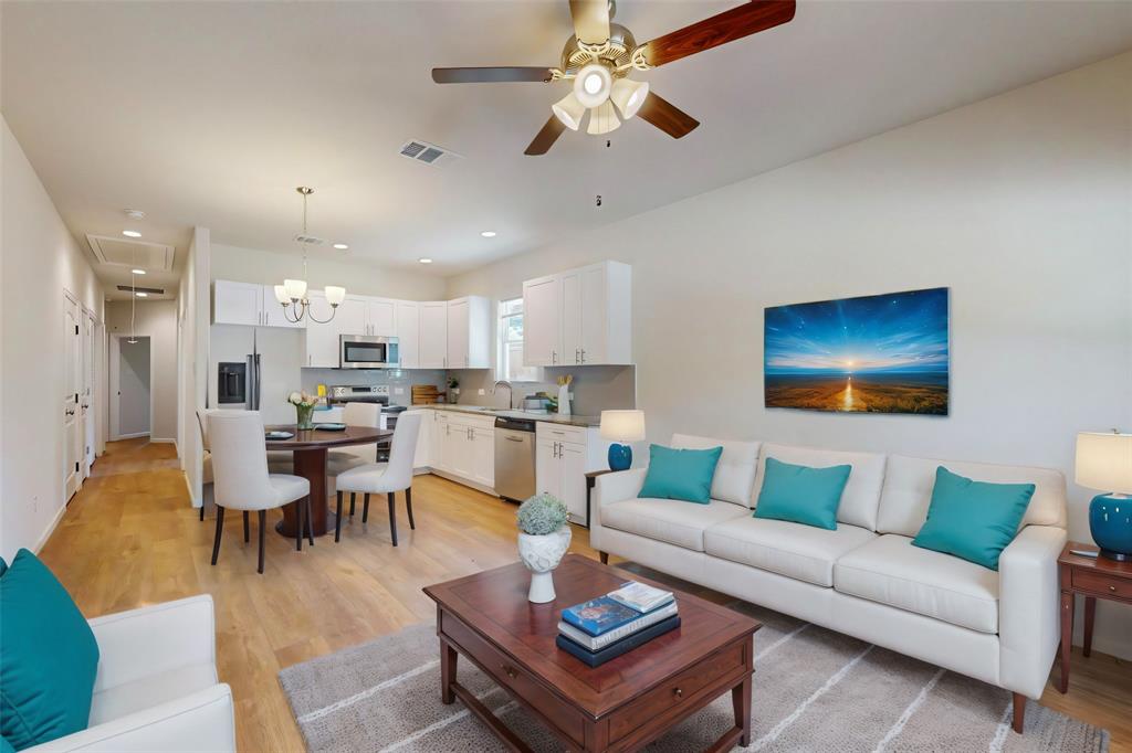 a living room with furniture kitchen view and a chandelier