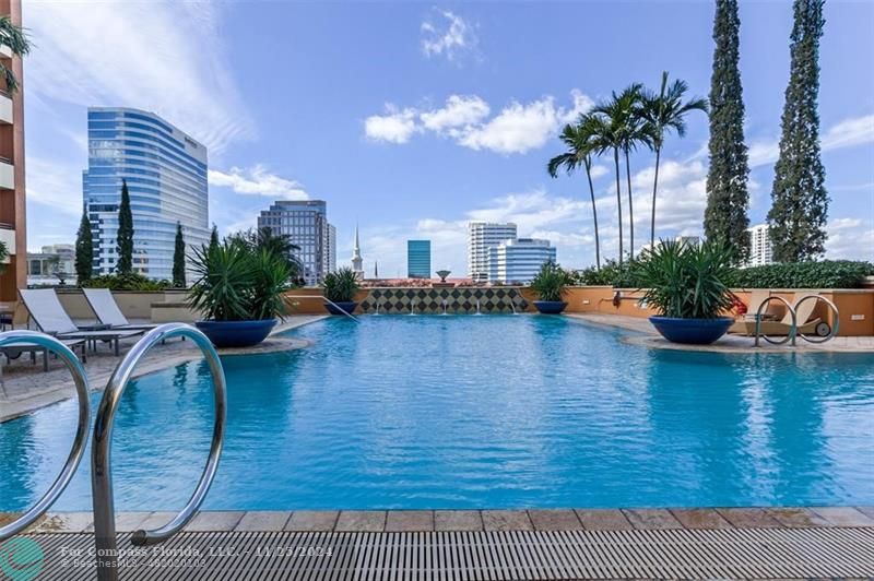 a swimming pool with outdoor seating and plants