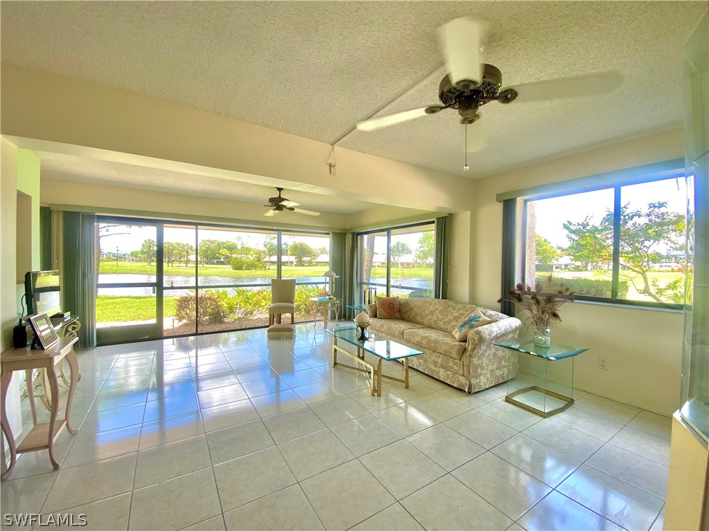 a living room with furniture and floor to ceiling windows