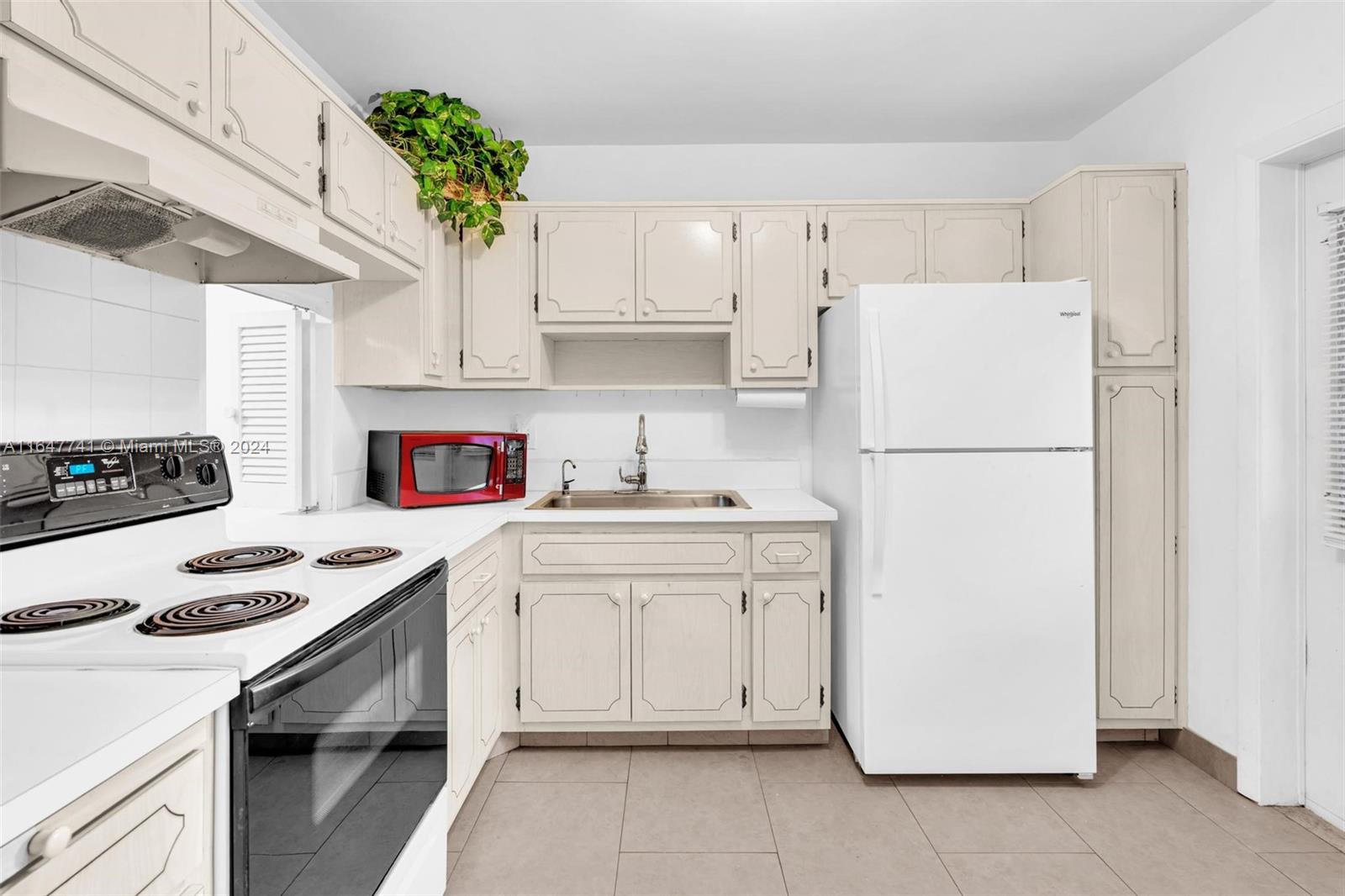 a kitchen with a white stove top oven and white refrigerator