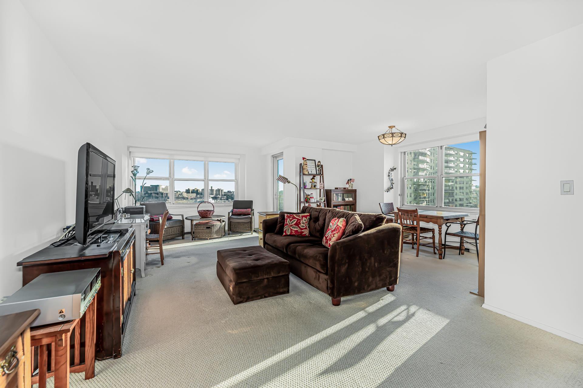 a living room with furniture a large window and flat screen tv