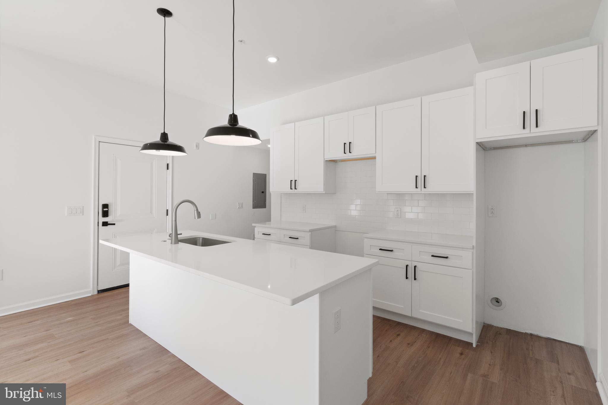 a kitchen with a sink a stove and wooden floor