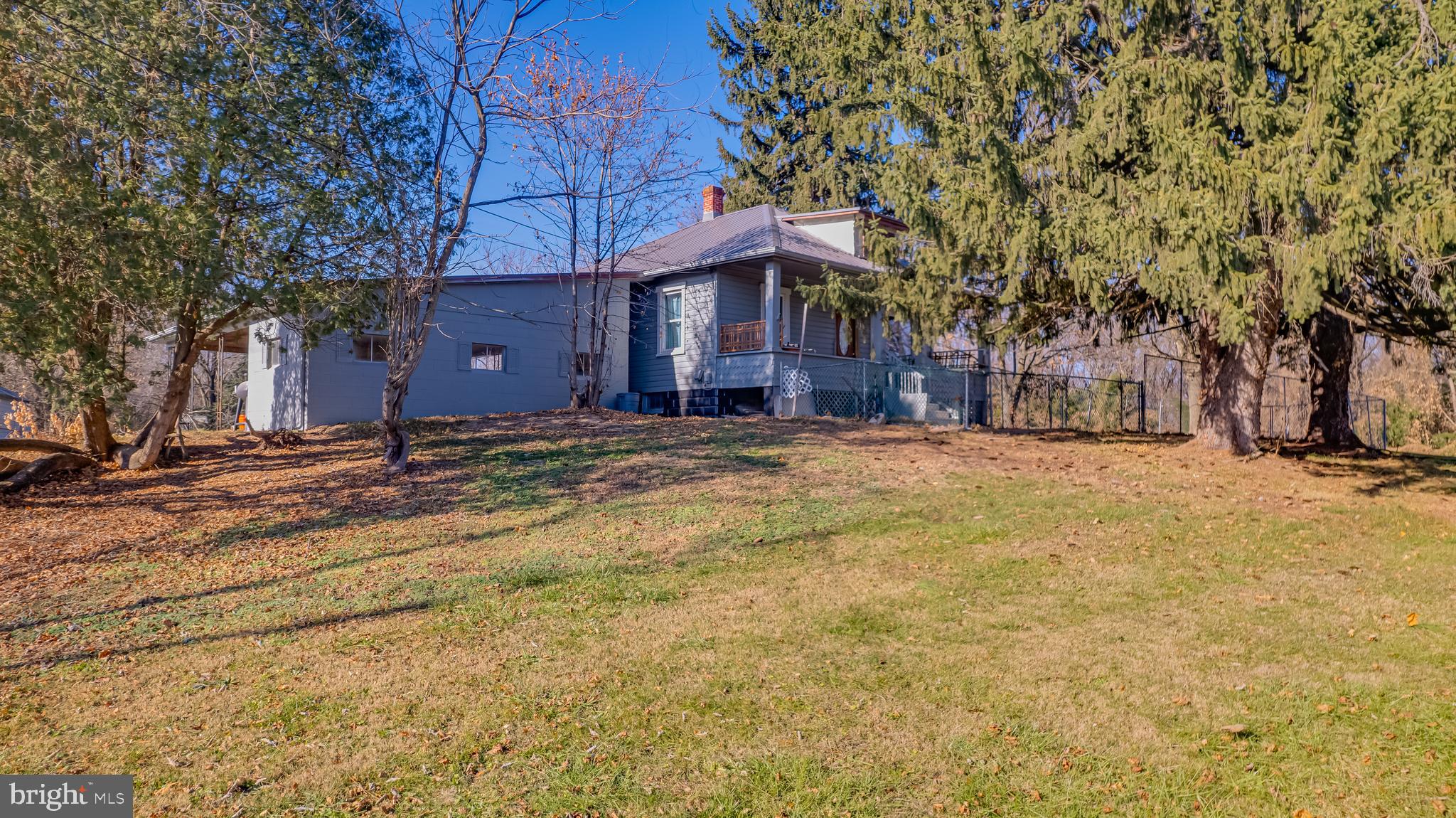 a view of a house with a yard covered with snow and trees