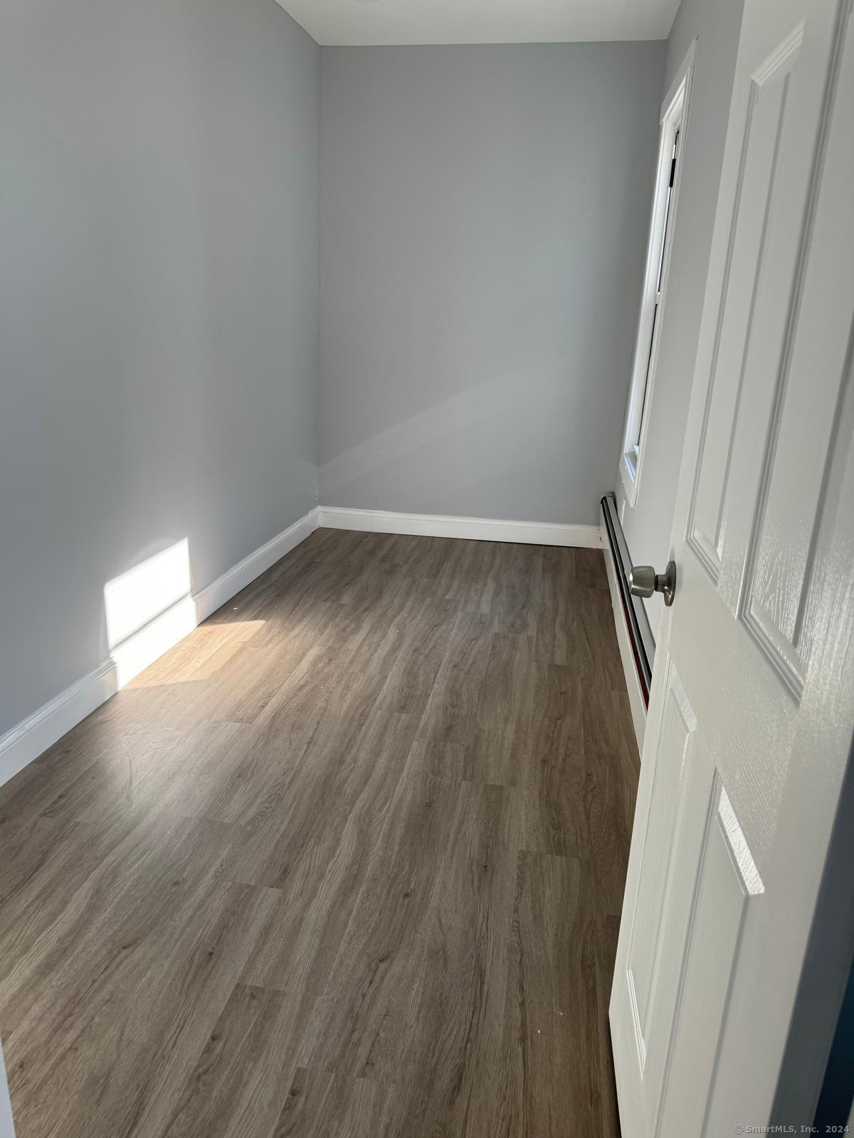 a view of a room with wooden floor and white walls