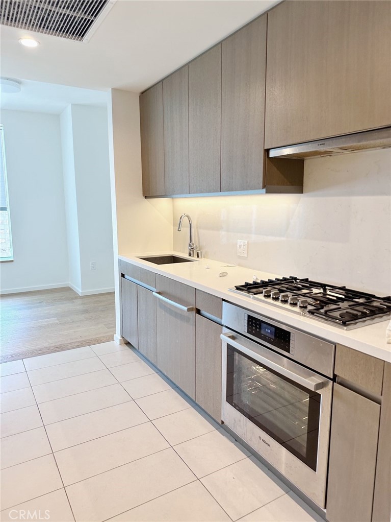 a kitchen with granite countertop a stove a sink and a microwave