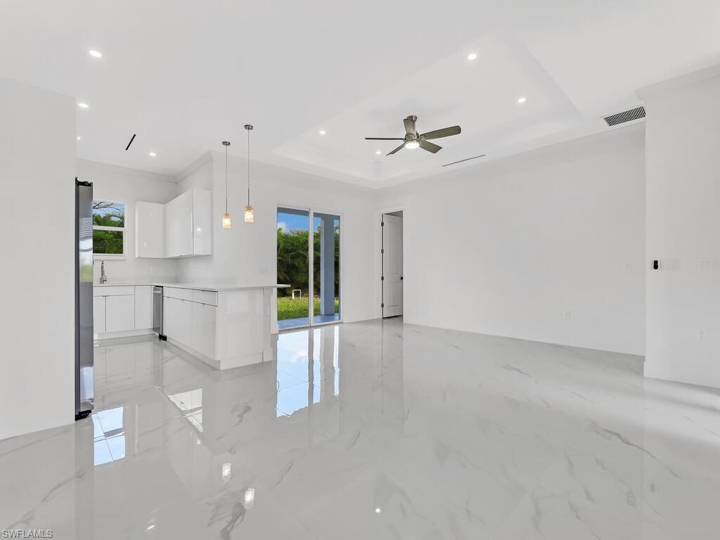 a view of kitchen with stainless steel appliances refrigerator oven and white cabinets