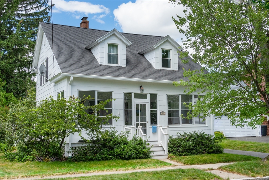 a front view of a house with a yard and potted plants