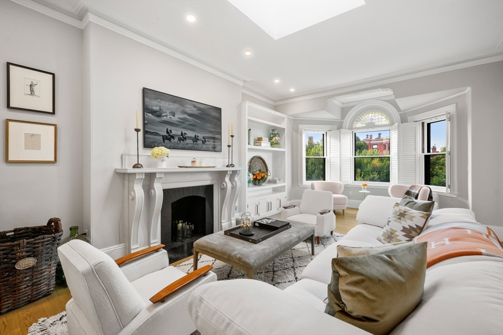 a living room with furniture large window and a fireplace