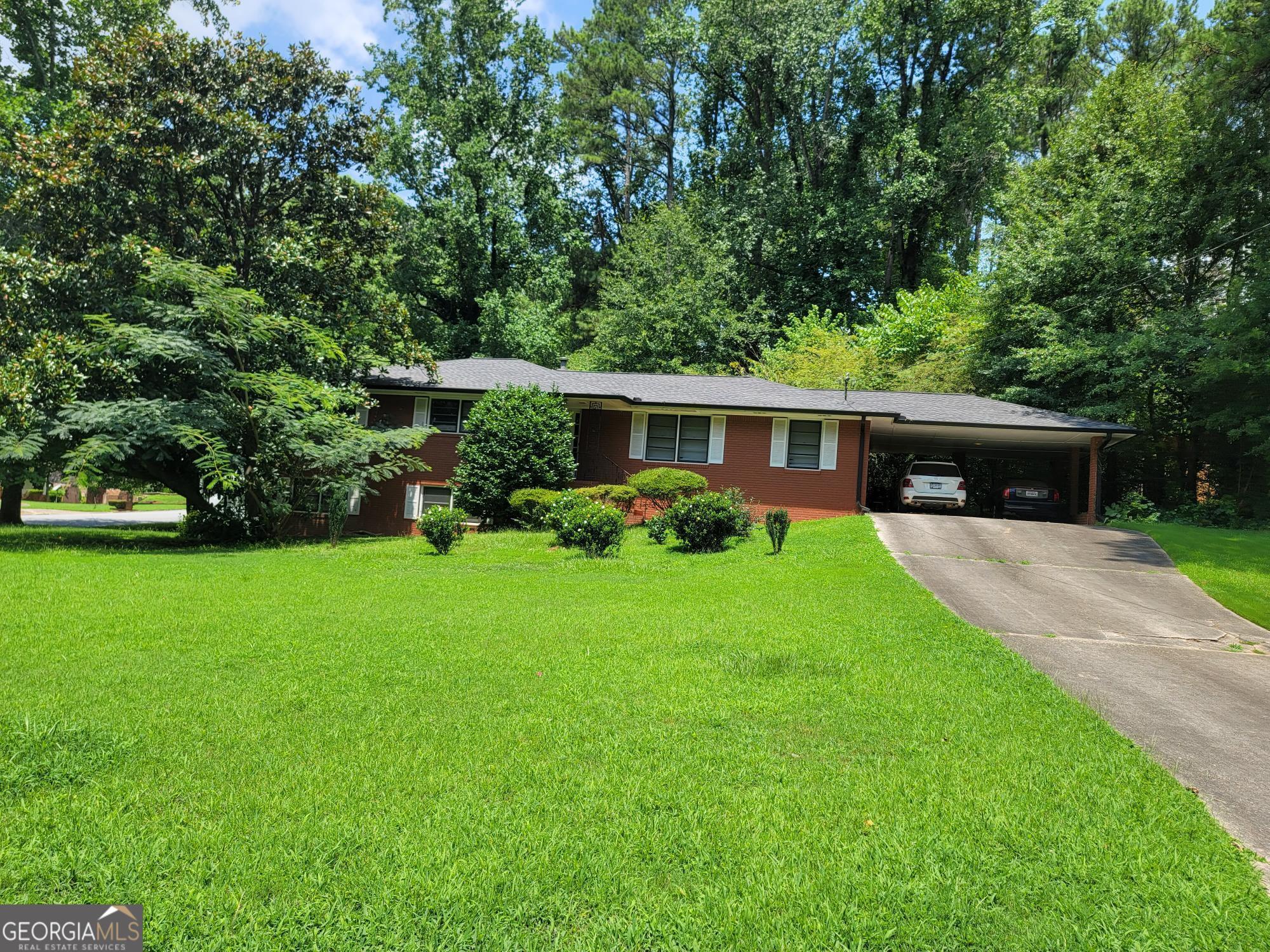 a front view of house with a yard and green space