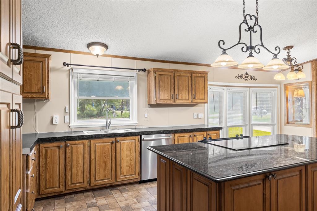 a kitchen with granite countertop a sink cabinets and window