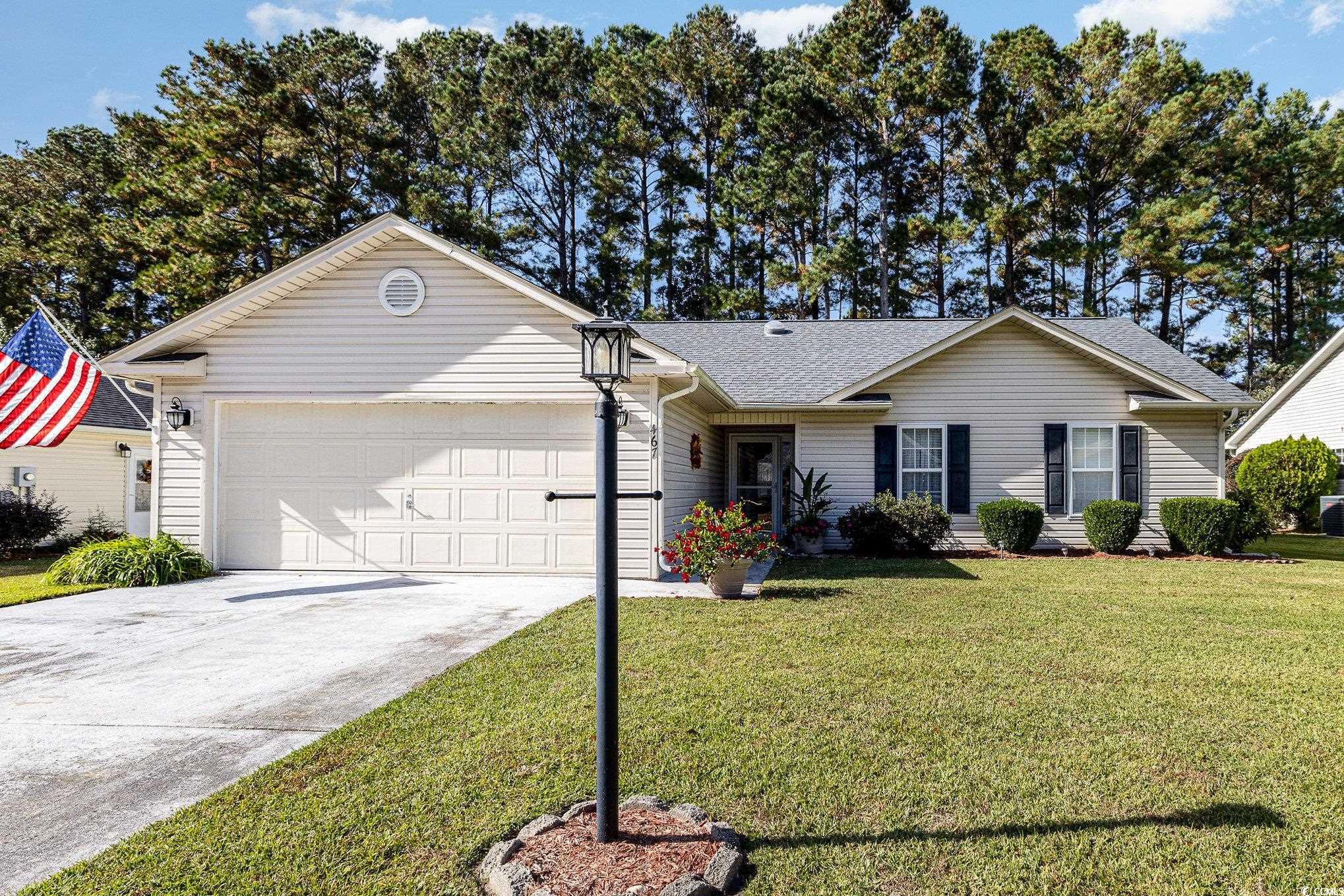 Ranch-style home featuring a garage and a front ya