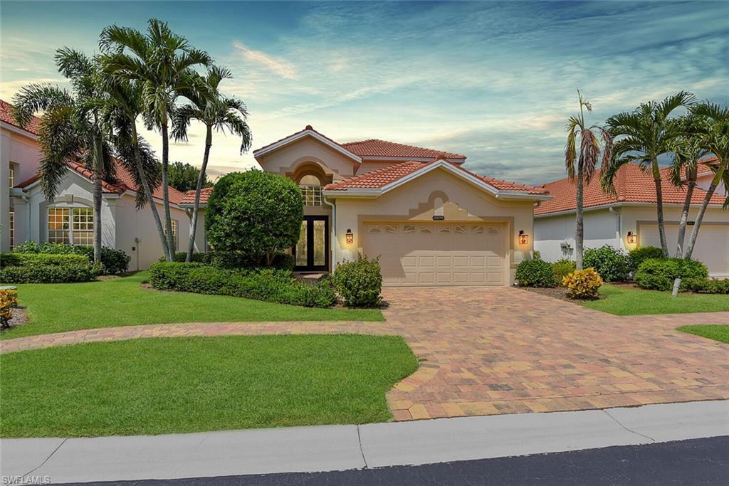 a front view of a house with a garden and yard