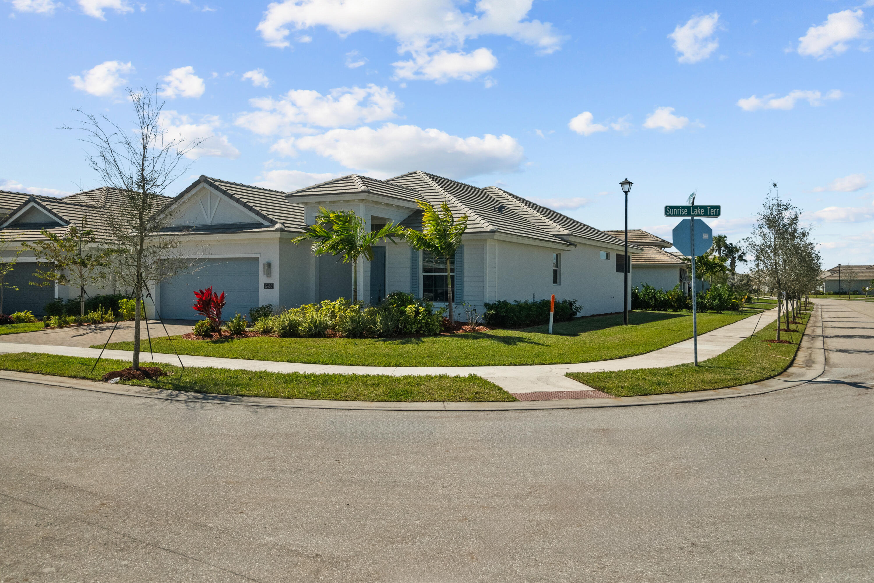 a view of a house with a big yard and potted plants