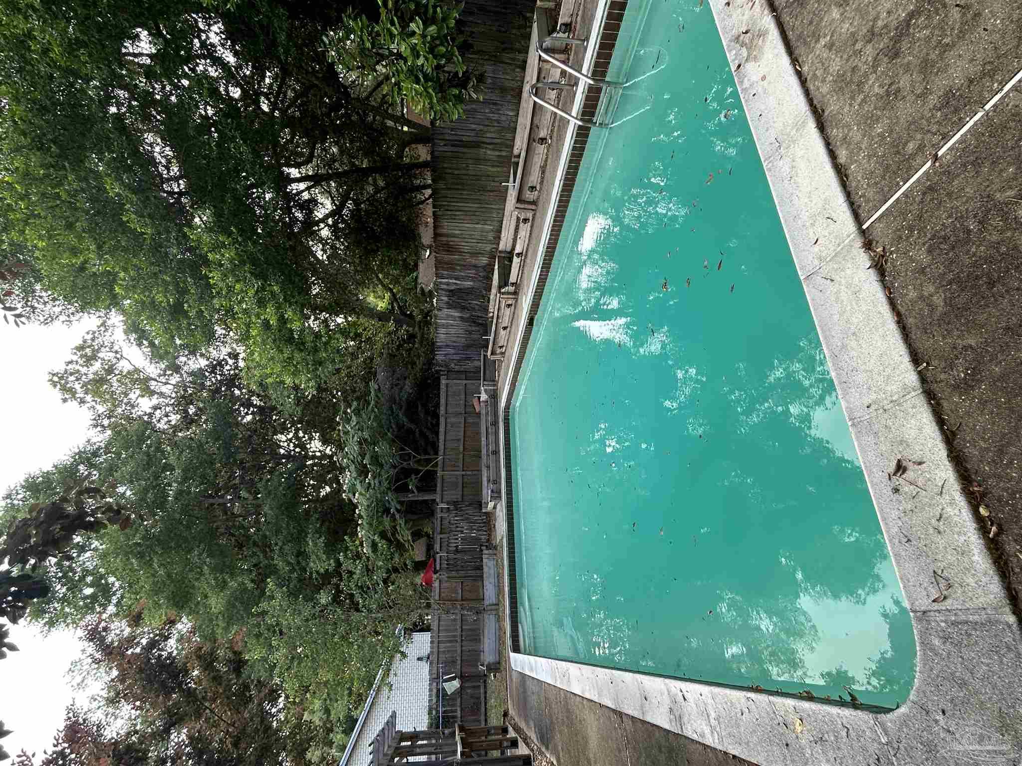 a view of a swimming pool with a yard and sitting area