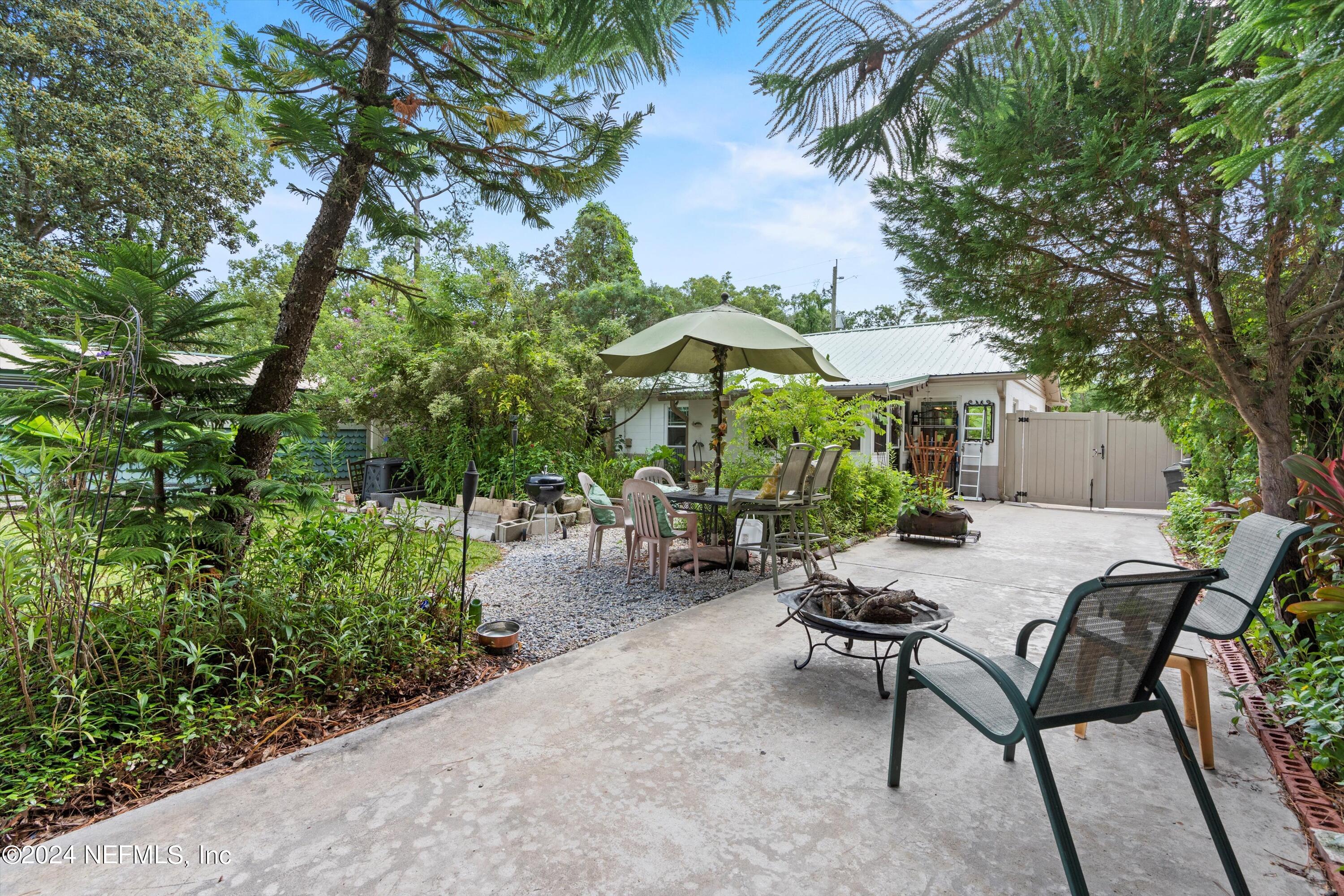 a view of a backyard with furniture and a garden