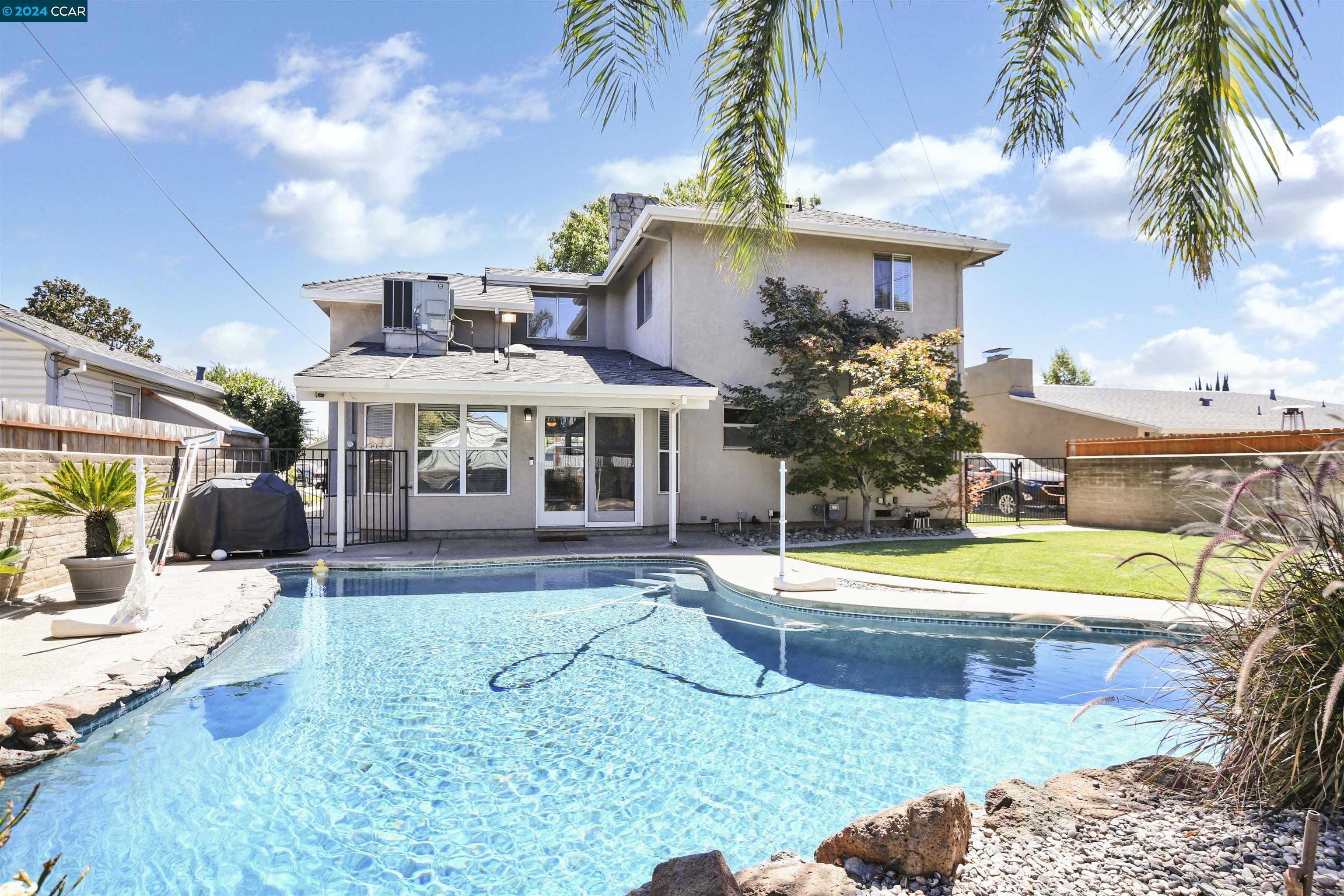 a view of a house with swimming pool yard and a patio