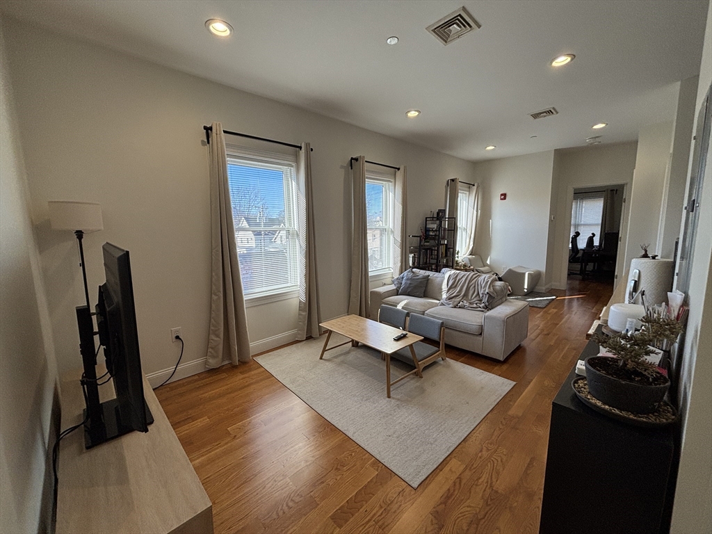 a living room with furniture rug and a large mirror