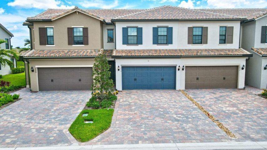 a front view of a house with a garage and a yard