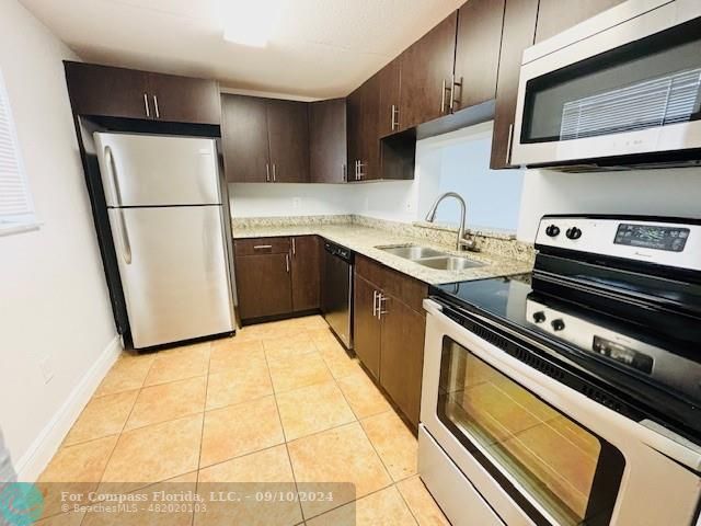 a kitchen with a sink a stove and a refrigerator