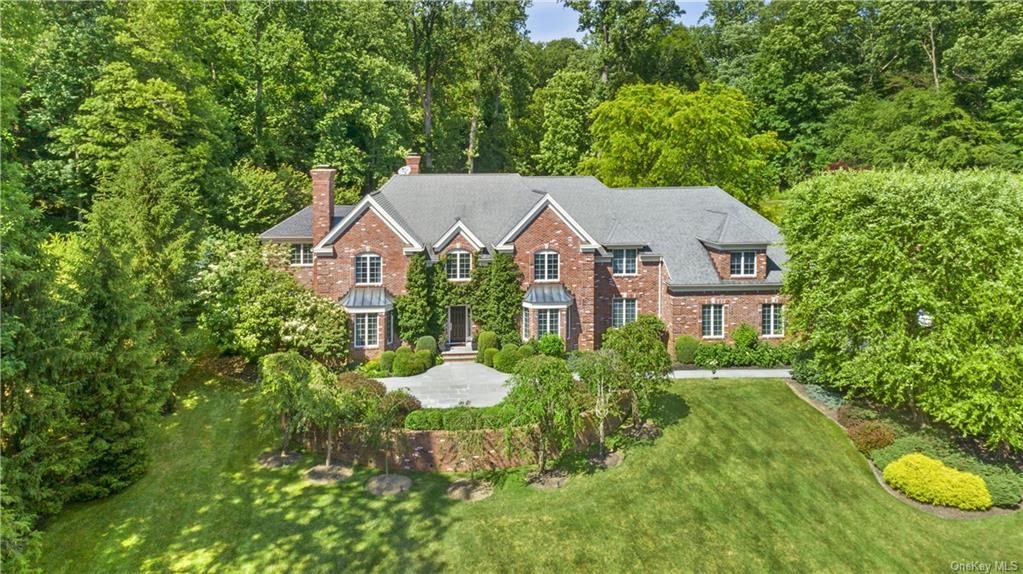 a aerial view of a house with yard and trees in the background