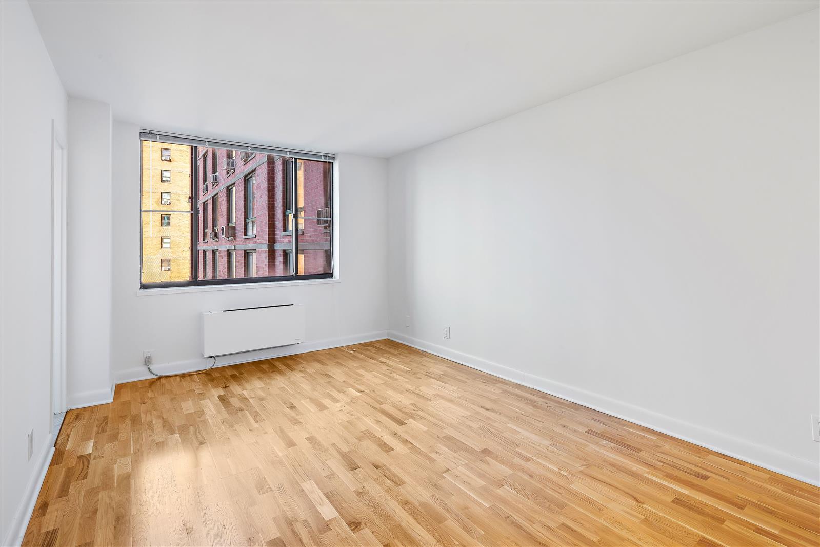 a view of a room with wooden floor and windows