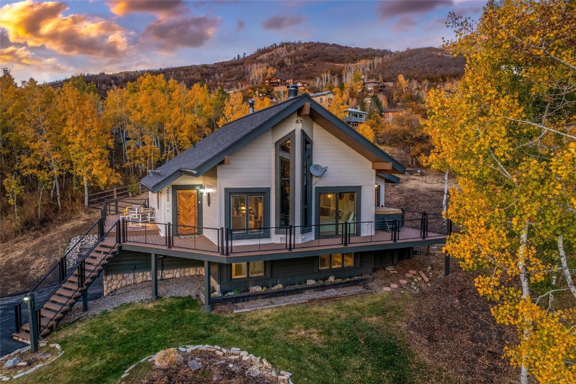 a view of a house with a wooden deck and a yard