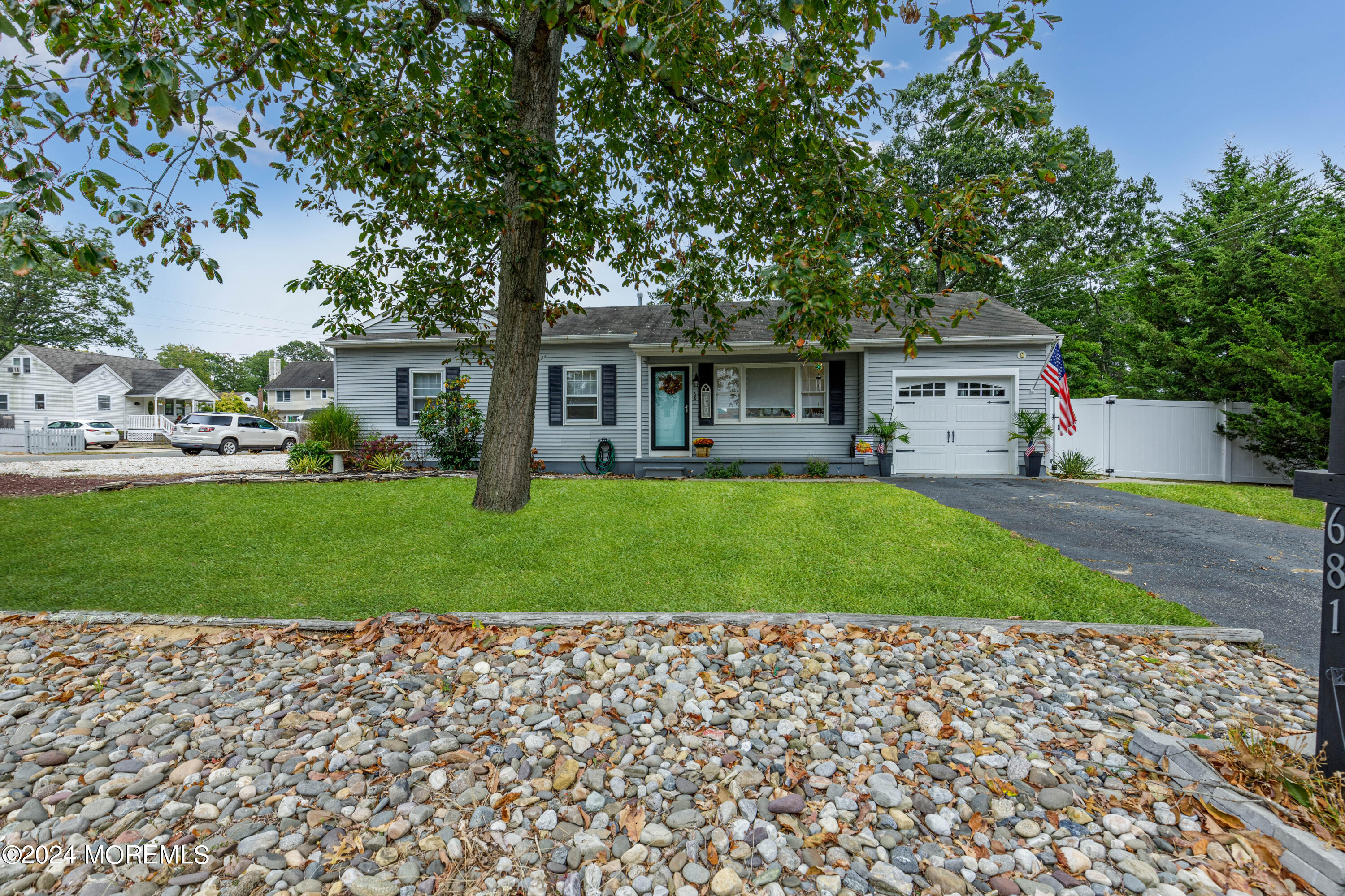 a front view of a house with a yard and trees