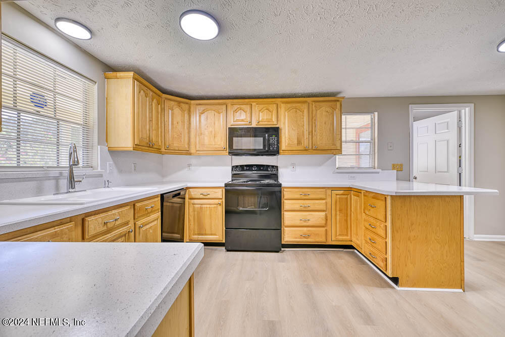 a kitchen with granite countertop white cabinets and wooden floor