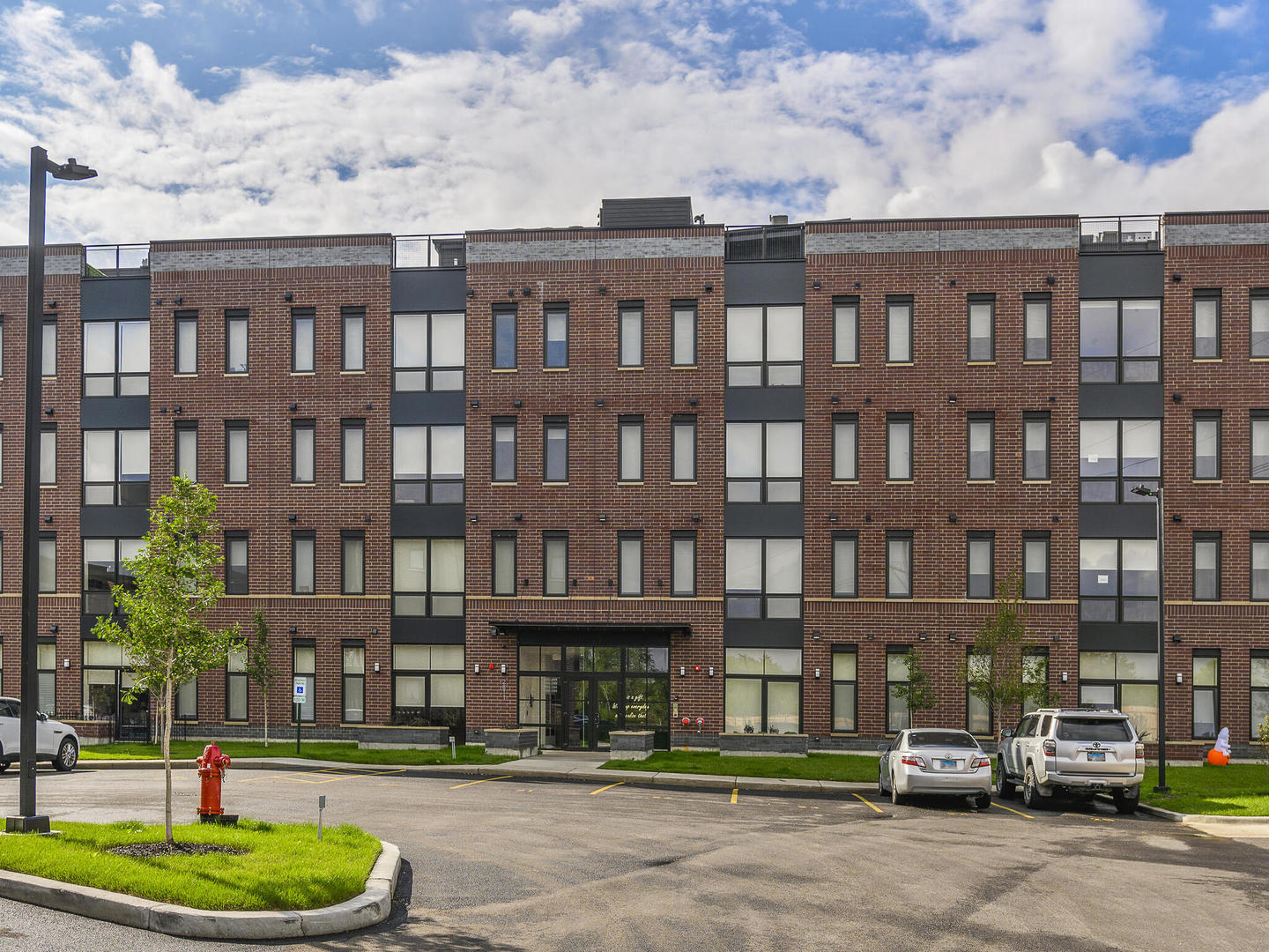 a front view of a residential apartment building with a yard