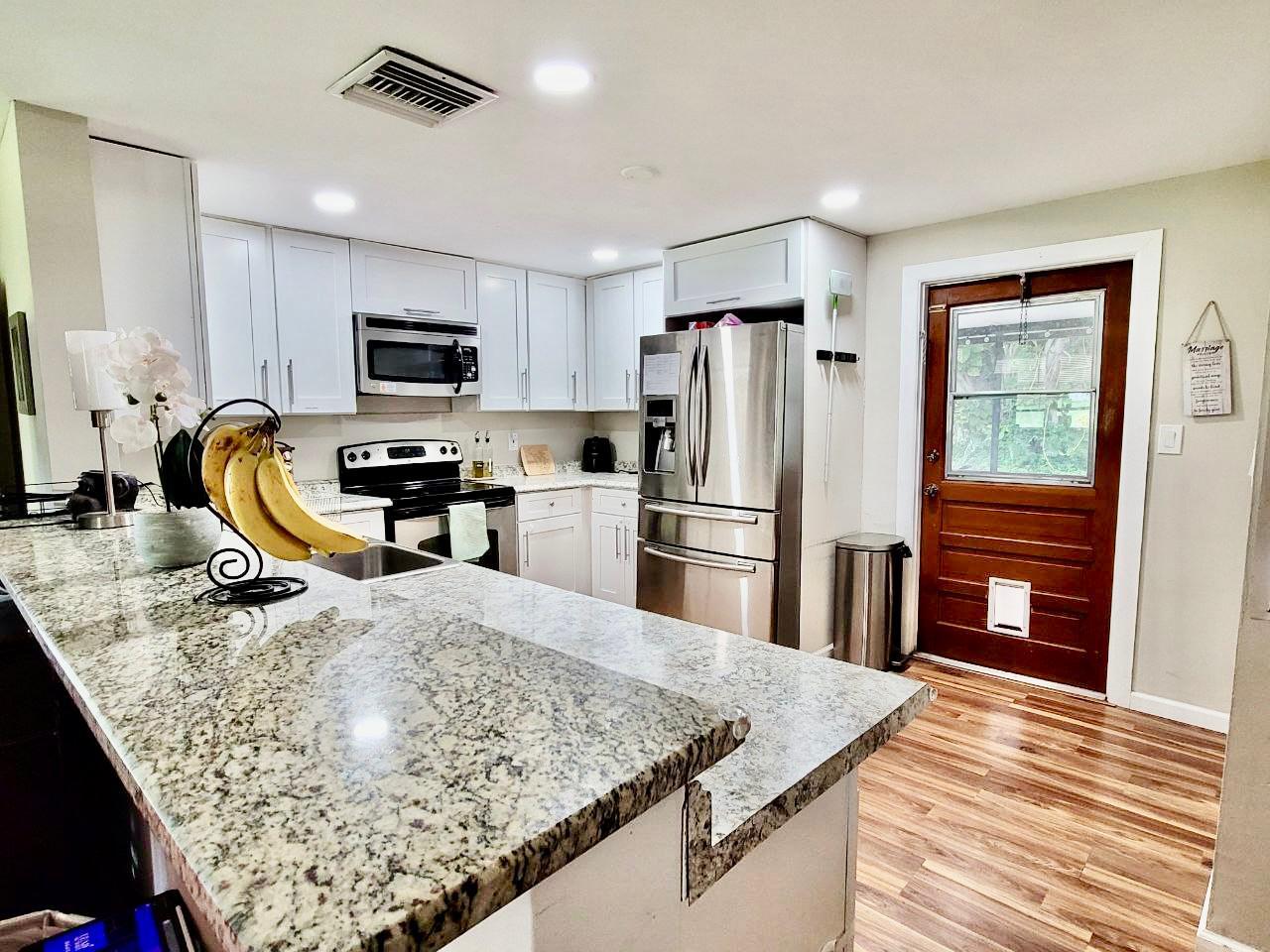 a kitchen with stainless steel appliances granite countertop a sink refrigerator and microwave