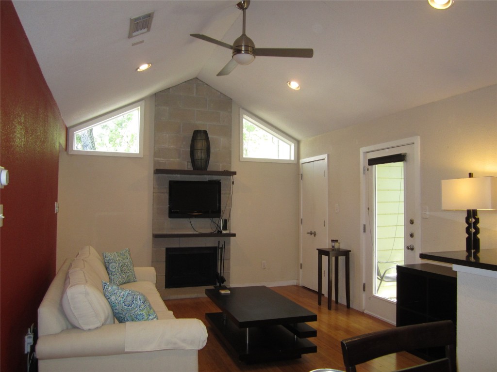 a living room with furniture a fireplace and a flat screen tv