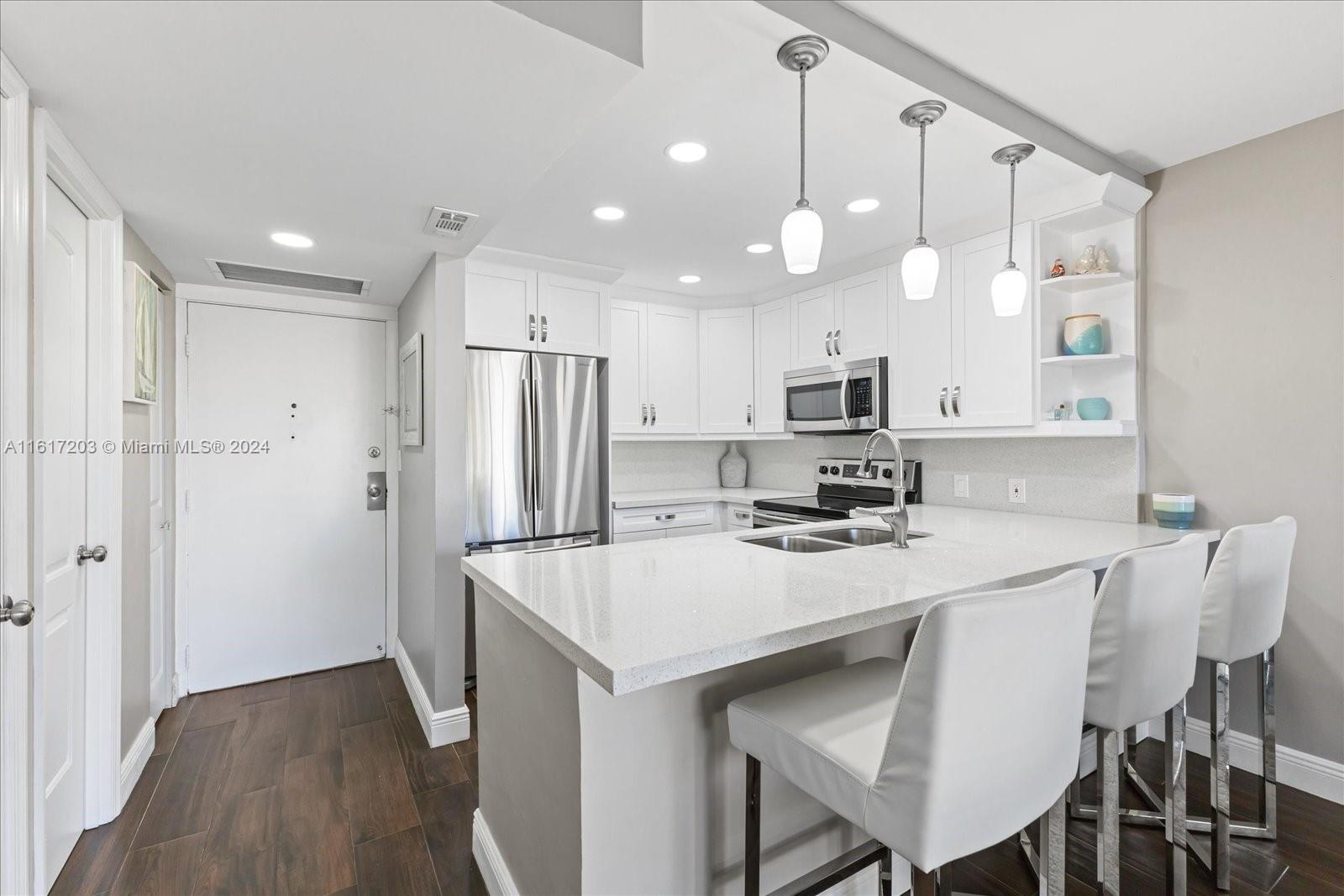 a kitchen with stainless steel appliances a refrigerator and a stove top oven