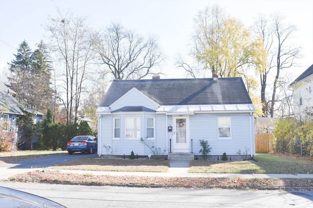 a view of a house with a yard and large tree