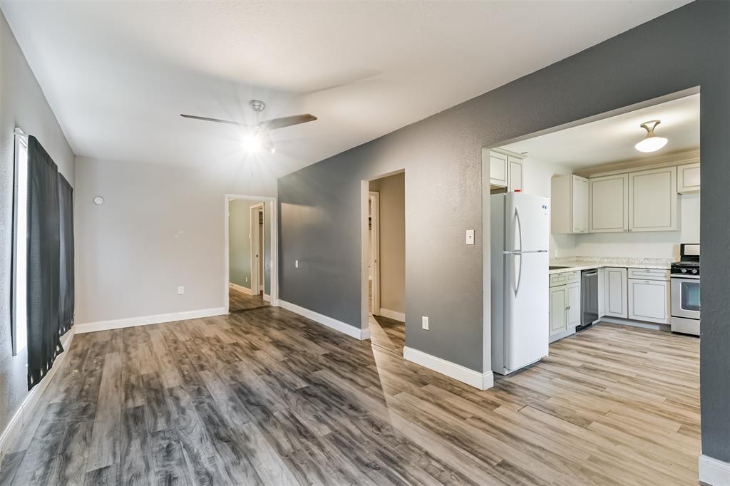 a view of a big room with wooden floor and a kitchen