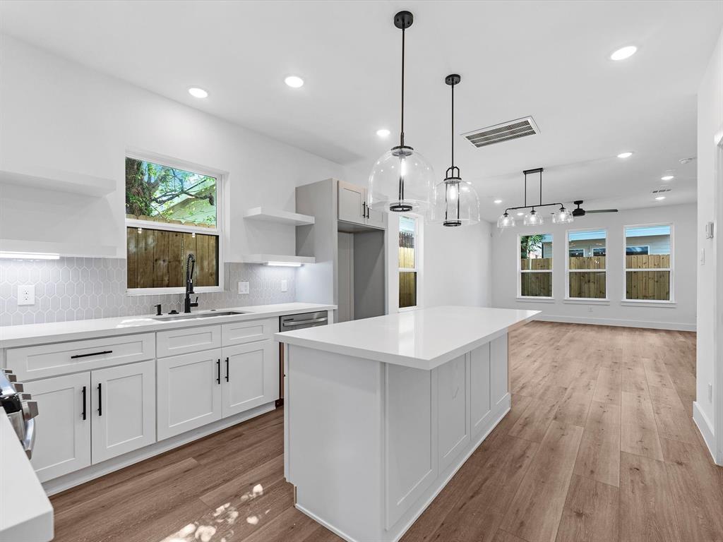 a large kitchen with kitchen island a large island in it