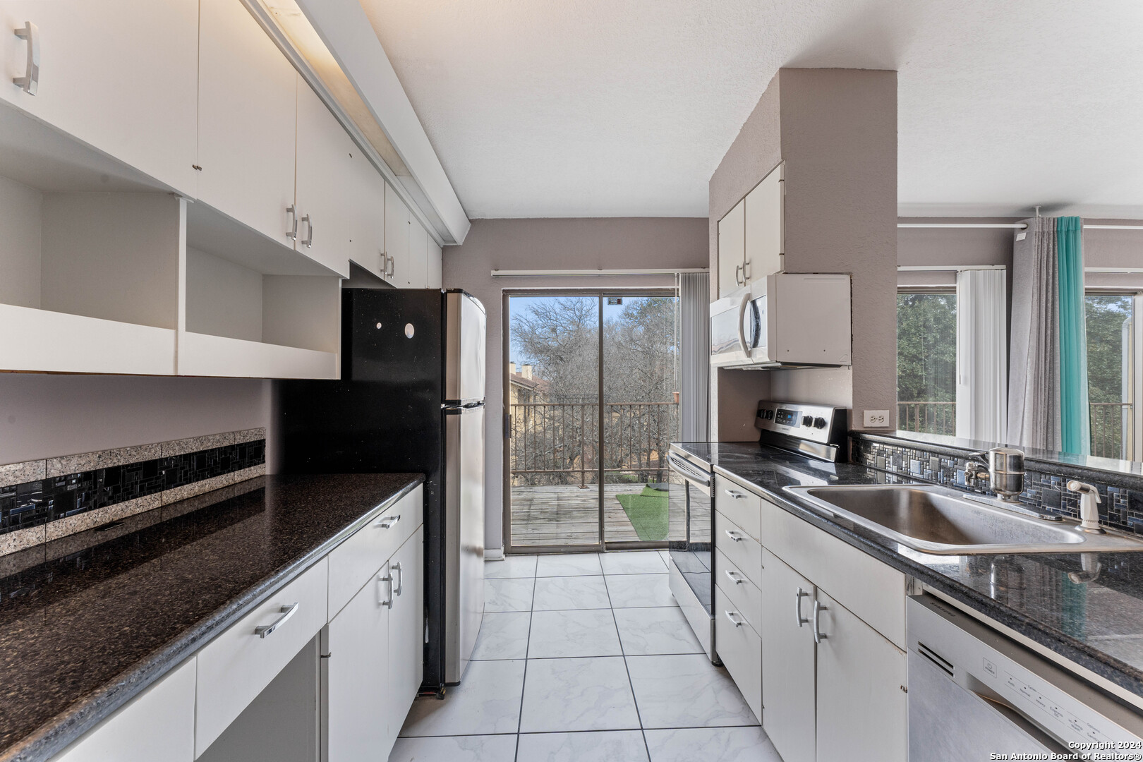 a kitchen with a sink a stove and cabinets