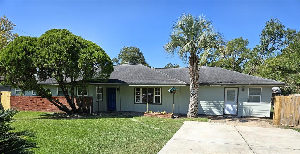 a front view of a house with a garden and trees