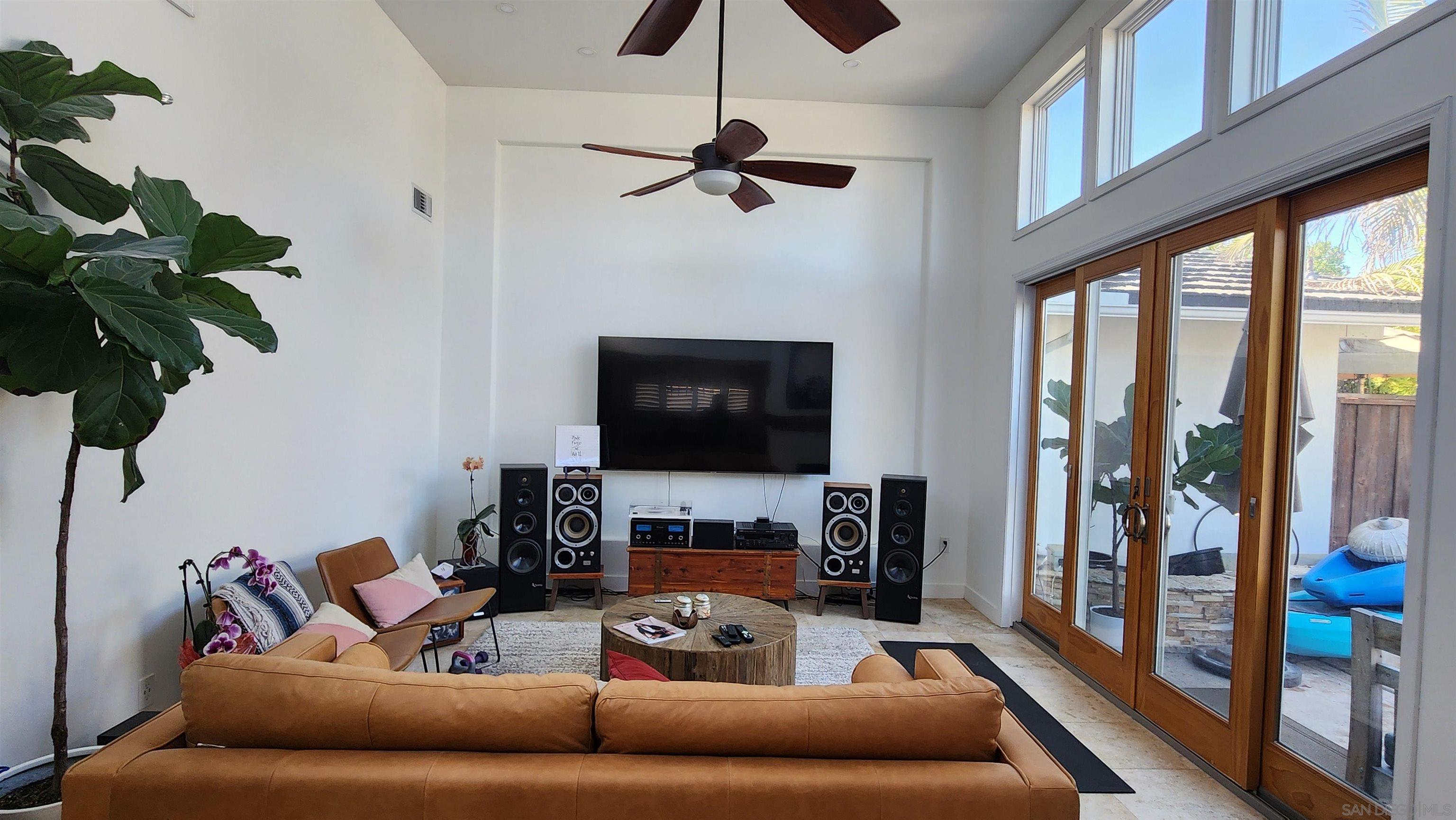 a living room with furniture a flat screen tv and a floor to ceiling window