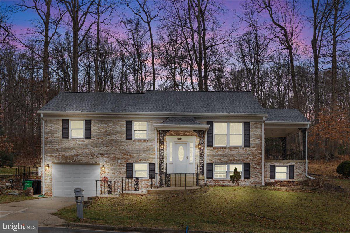 a front view of a house with garage and trees