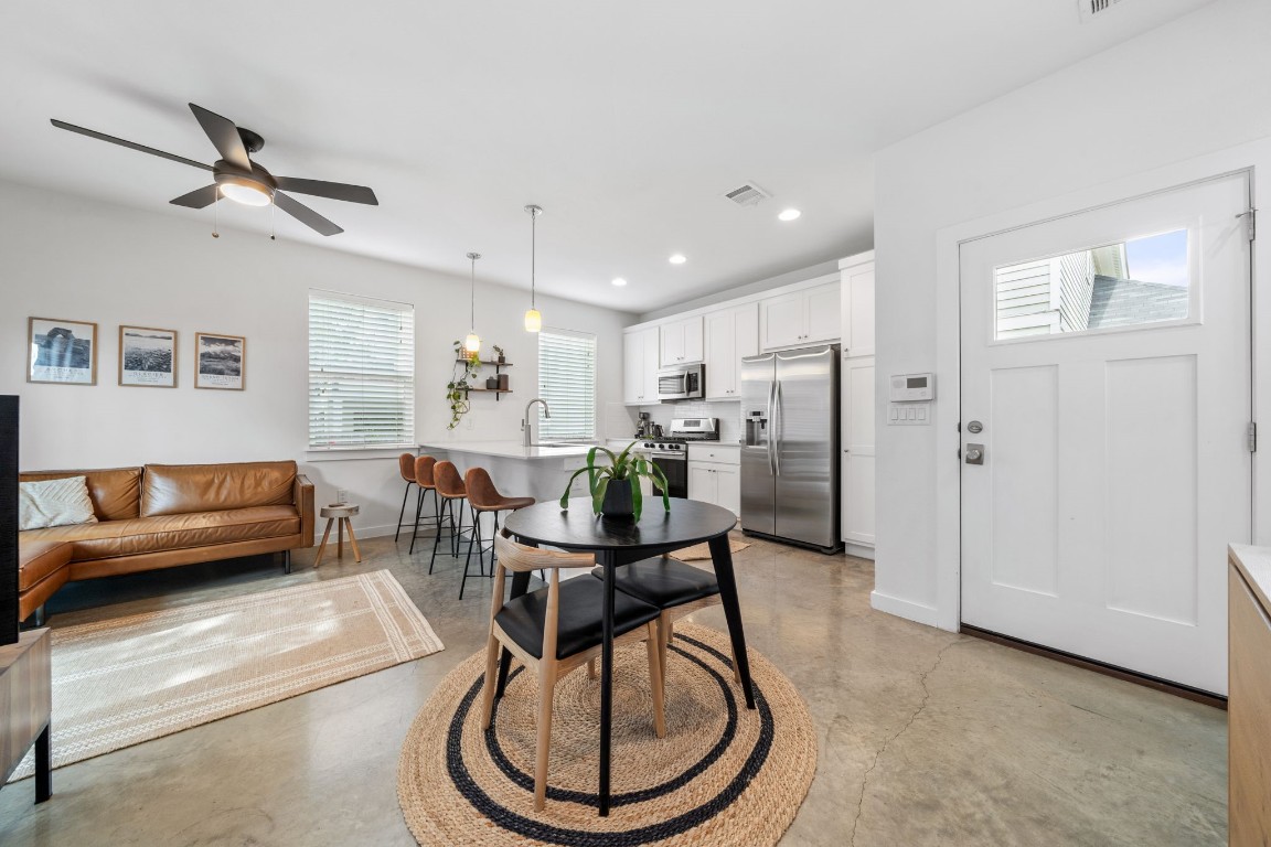 a living room with furniture a rug and kitchen view