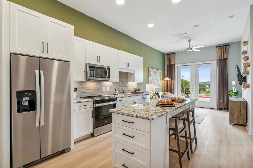 a kitchen with stainless steel appliances a stove refrigerator sink and microwave