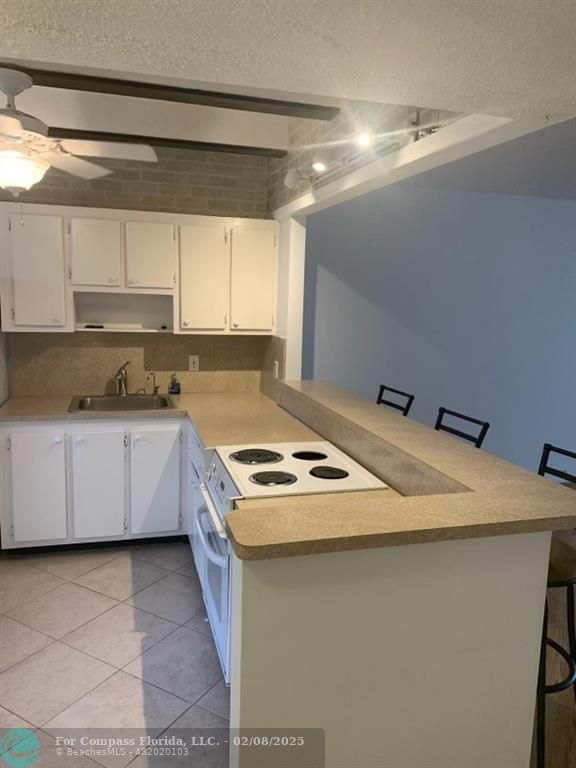 a kitchen with a stove sink and cabinets